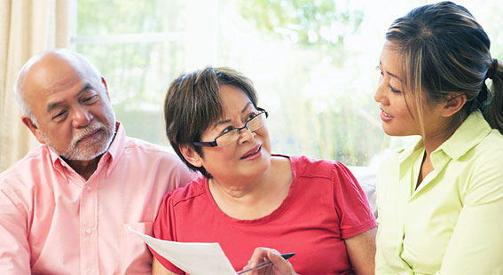 Three individuals engaged in conversation indoors.