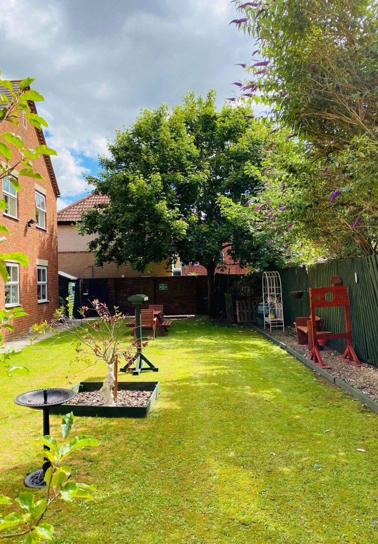 Lush garden area with seating and trees