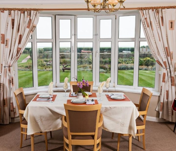 Dining area with large windows and garden view