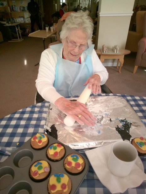 Resident decorating cupcakes during an activity.