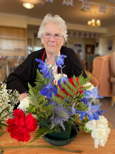 Resident arranging a colorful flower bouquet