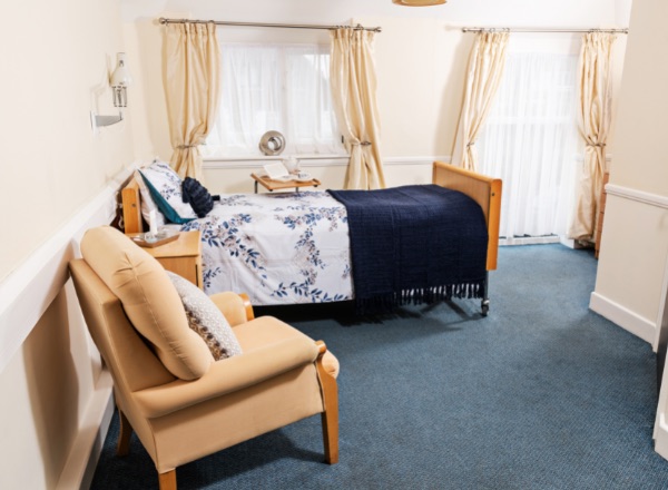 Cozy resident room with a bed and chair.