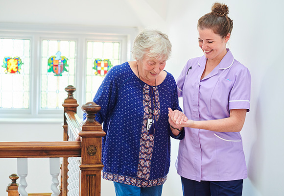 Caregiver assisting senior resident indoors