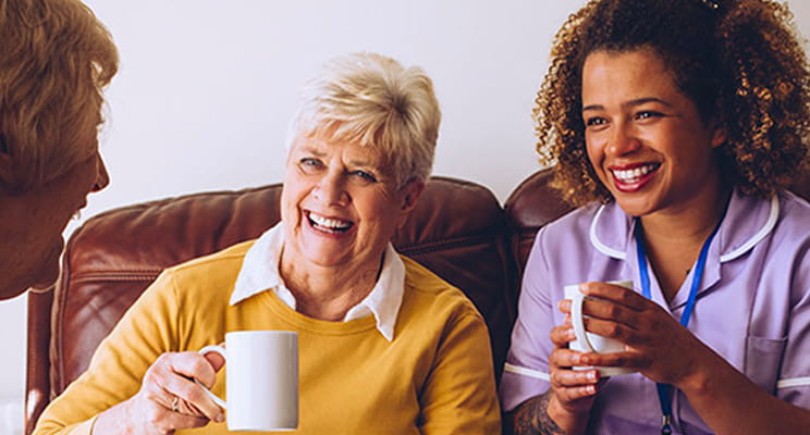 Residents and staff sharing smiles over coffee