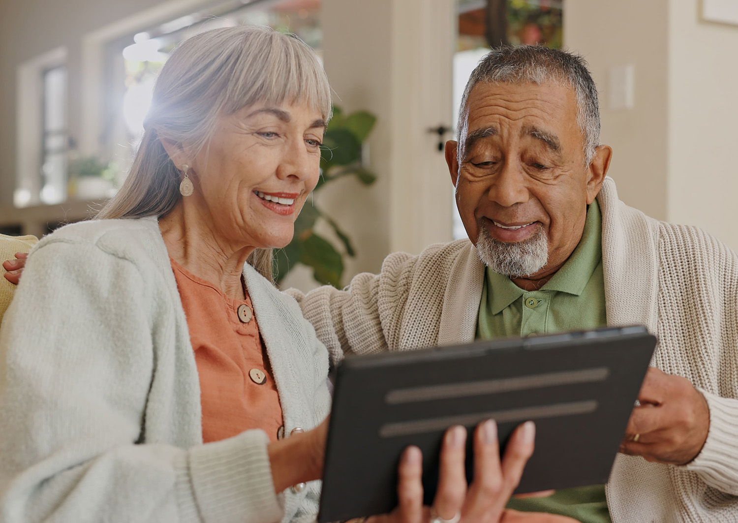 A senior couple interacting with a tablet.