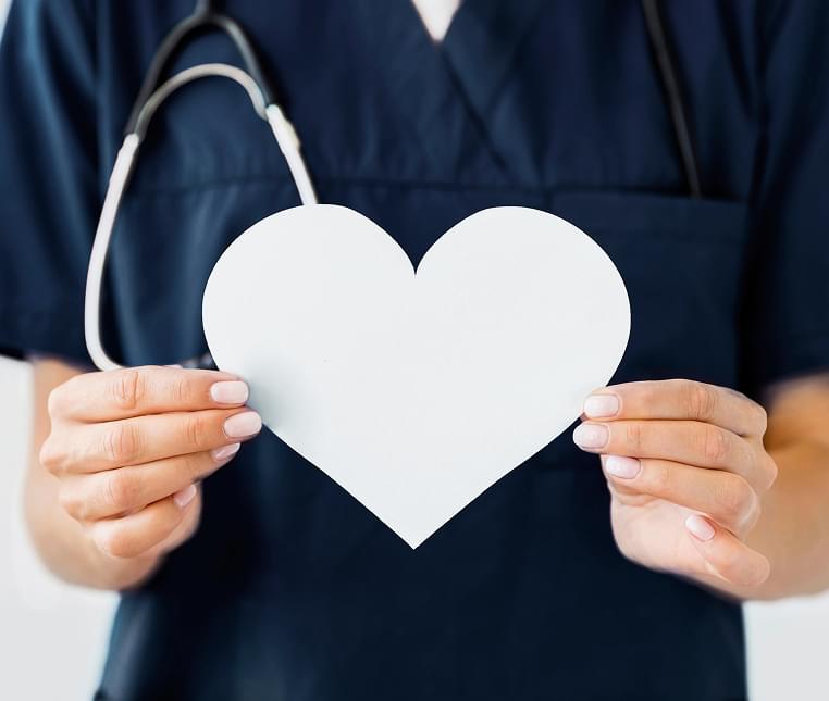 Healthcare worker holding a heart cutout