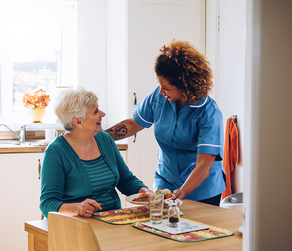 Staff member serving food to a resident