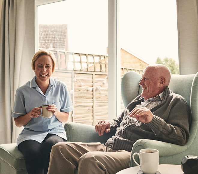 Staff member enjoying tea with a resident.