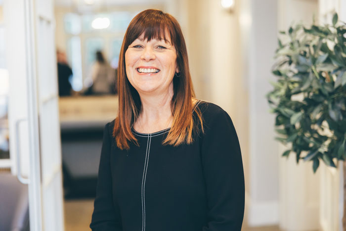 Friendly staff member smiling in a hallway