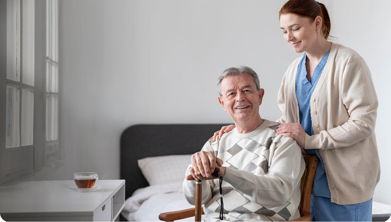 Smiling senior man with caregiver in a room