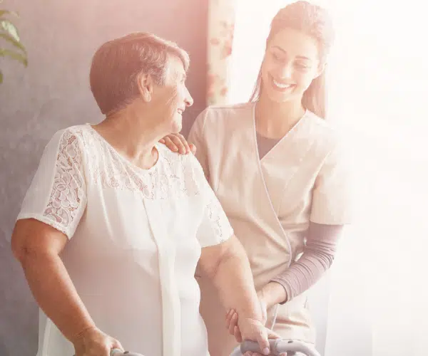 A caregiver assisting a senior resident indoors