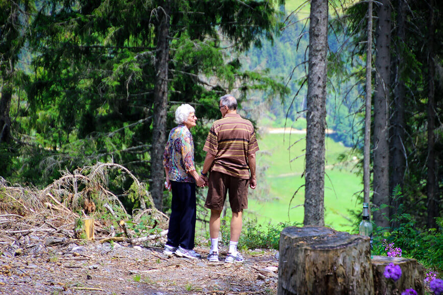Couple walking hand-in-hand in nature.