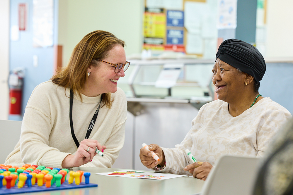 Staff member engaging with a resident in an activity.