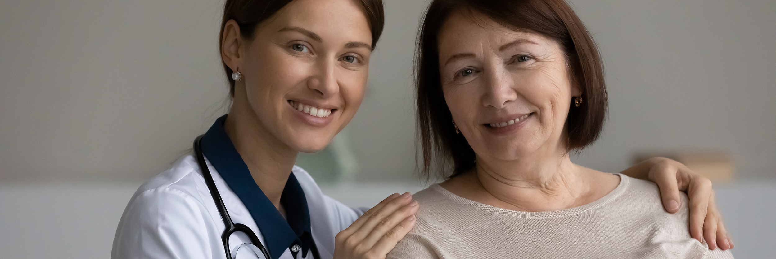 Healthcare professional with a senior resident smiling together.