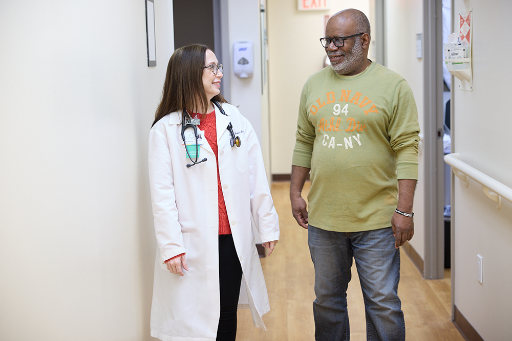 Doctor and patient conversing in a hallway
