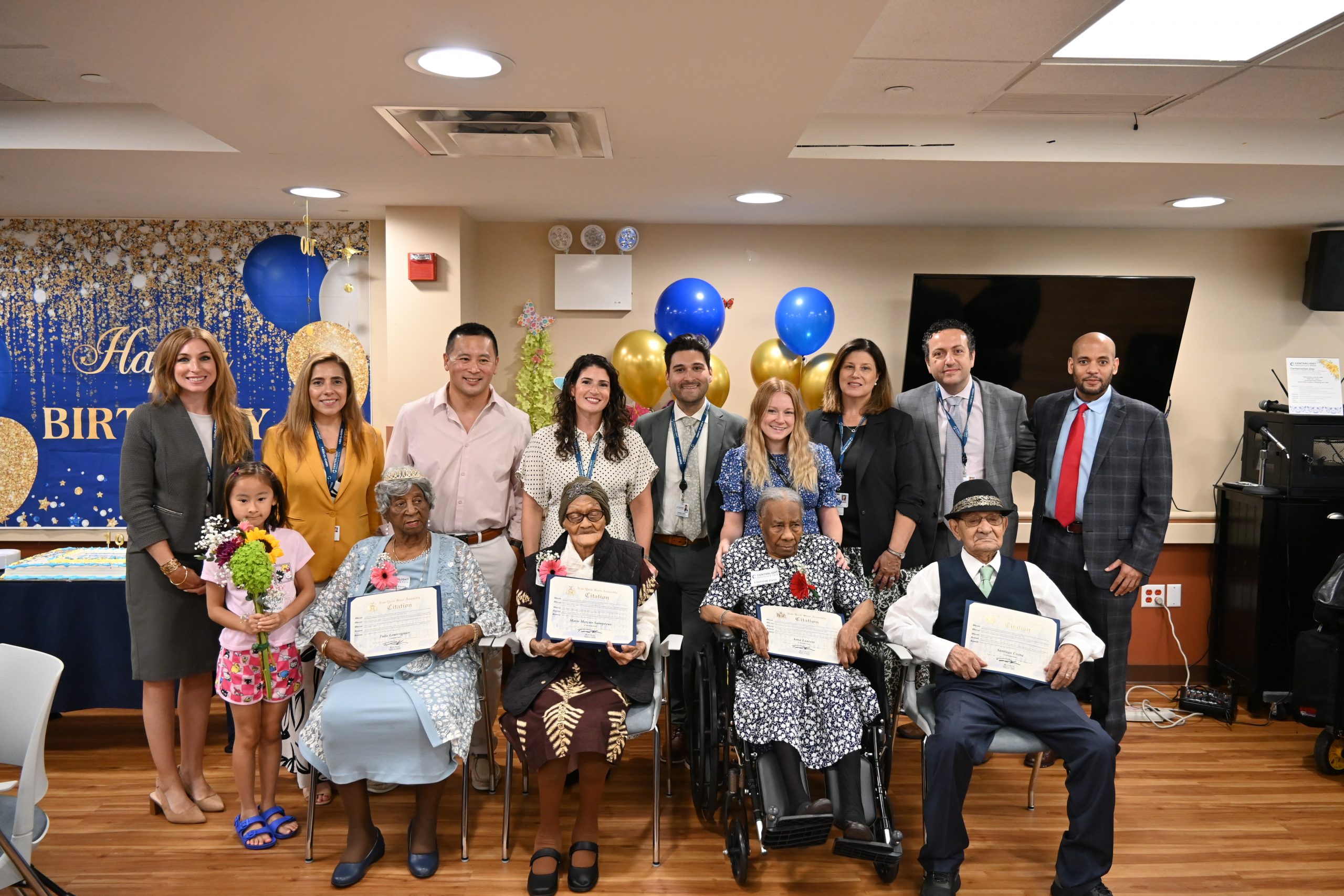 Residents, staff, and family celebrate a birthday event.