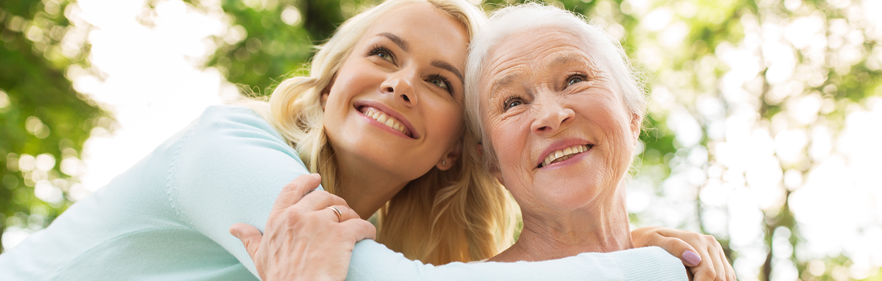Smiling senior woman with a younger companion outdoors