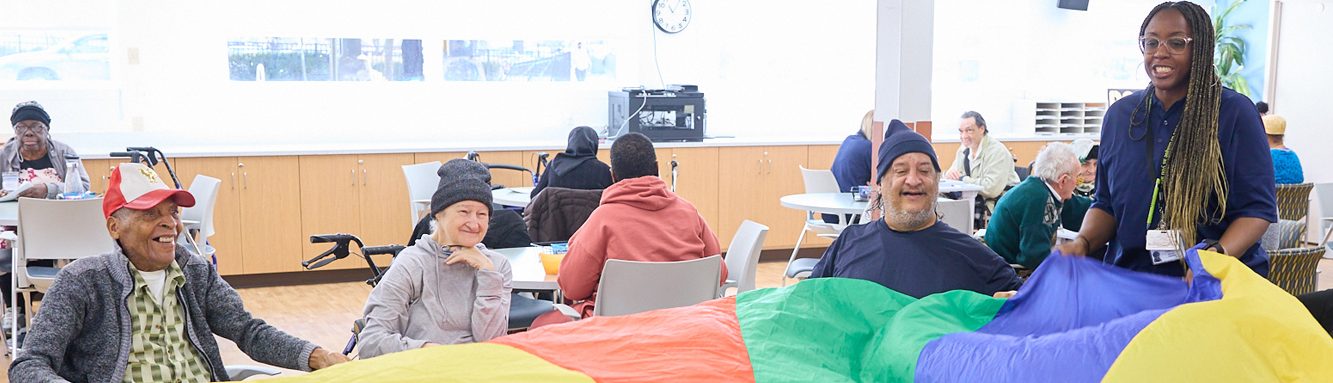 Residents participating in a group activity with colorful parachute.