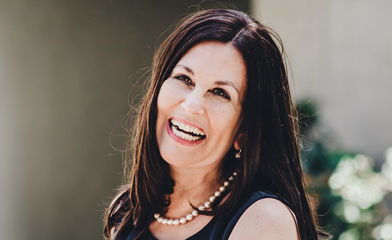 Smiling woman wearing a pearl necklace outdoors