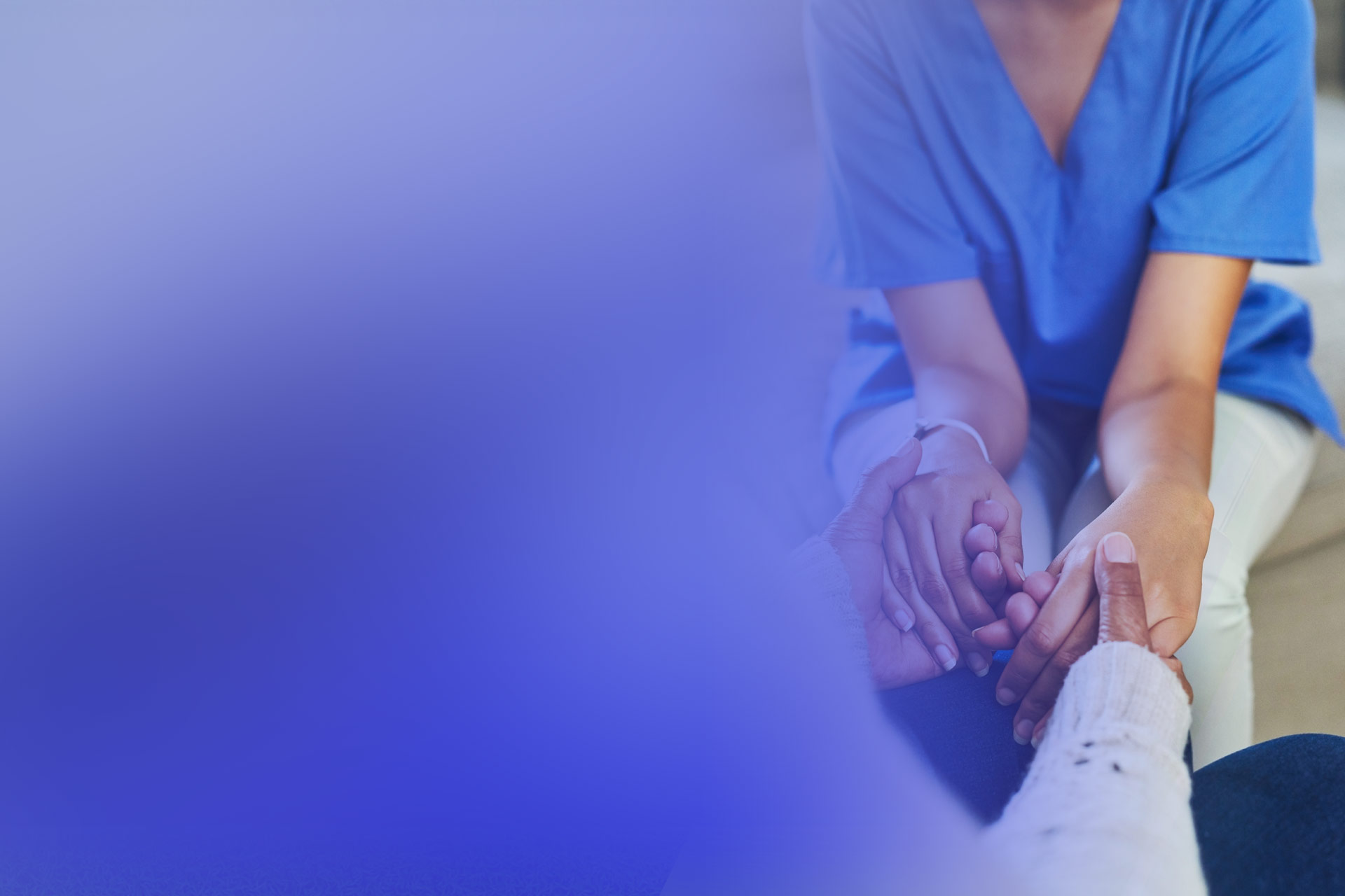 A caregiver's hands holding a senior's hands.