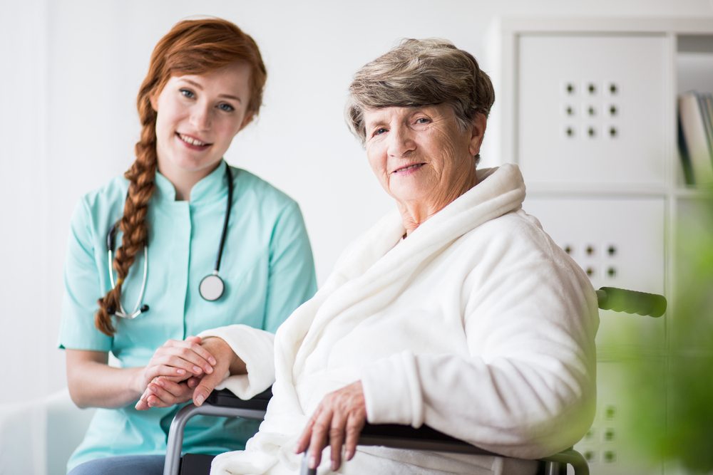Healthcare worker with elderly resident in a cozy setting.