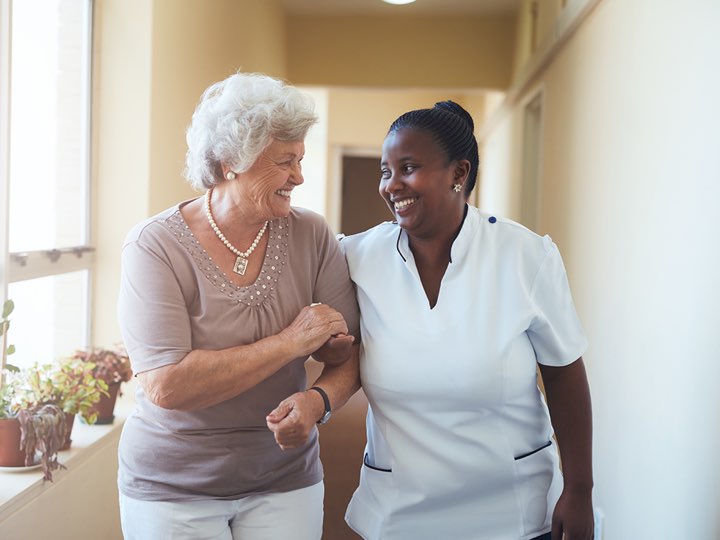 Staff member assisting a resident in a hallway