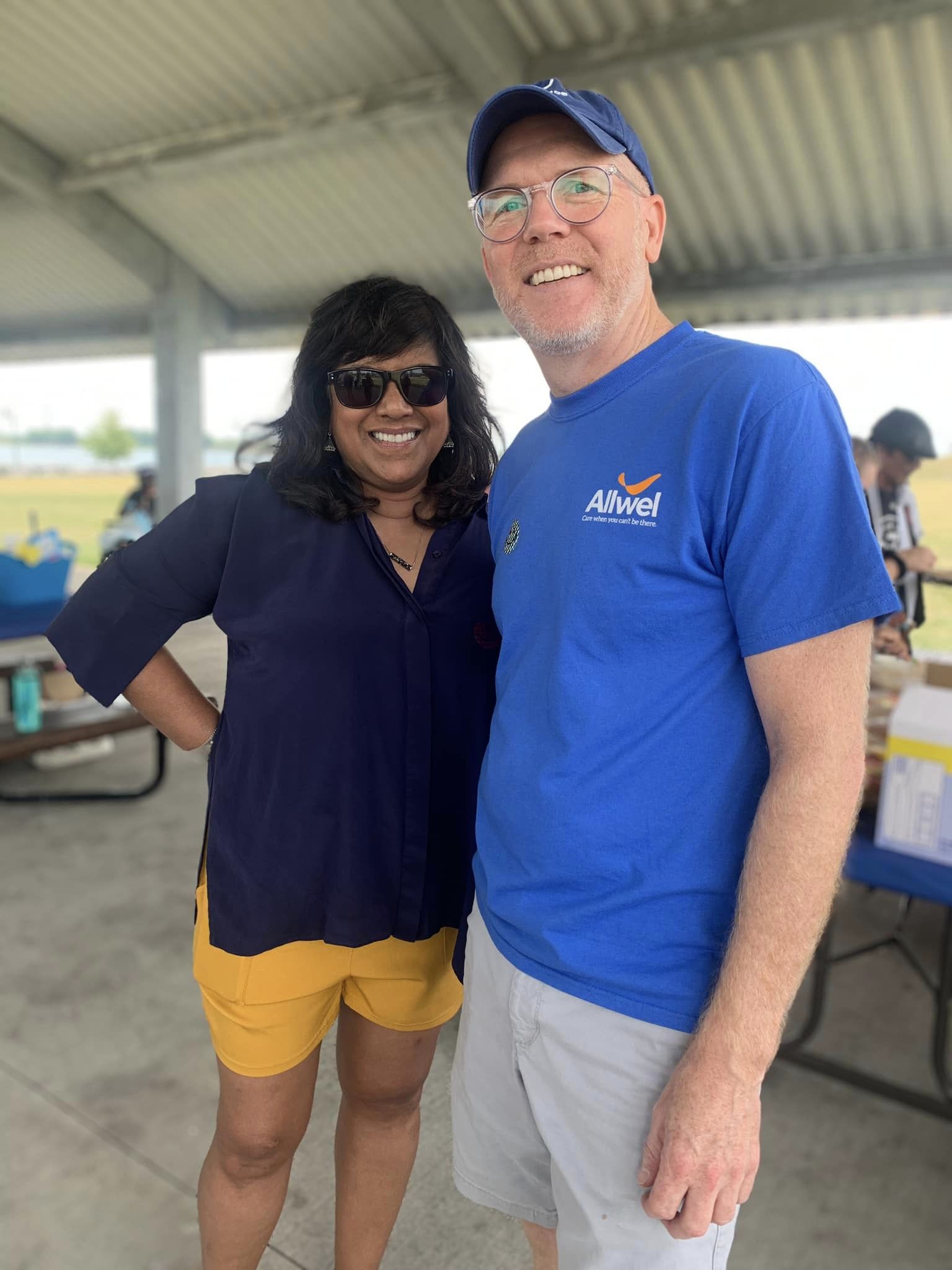 Two people smiling at an outdoor event.