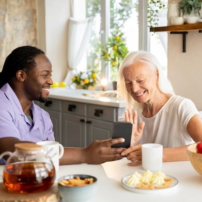 Senior woman enjoying tea and conversation with staff.
