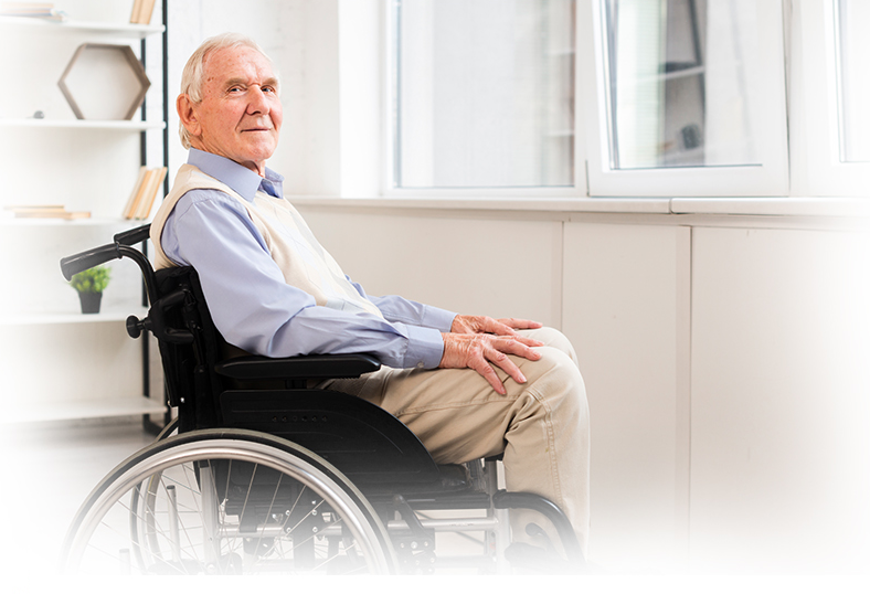 Senior man seated in a wheelchair indoors.