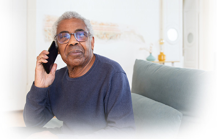 Senior man talking on the phone in an interior space.