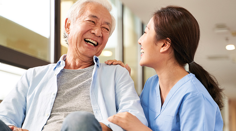 A caregiver laughing with an elderly resident