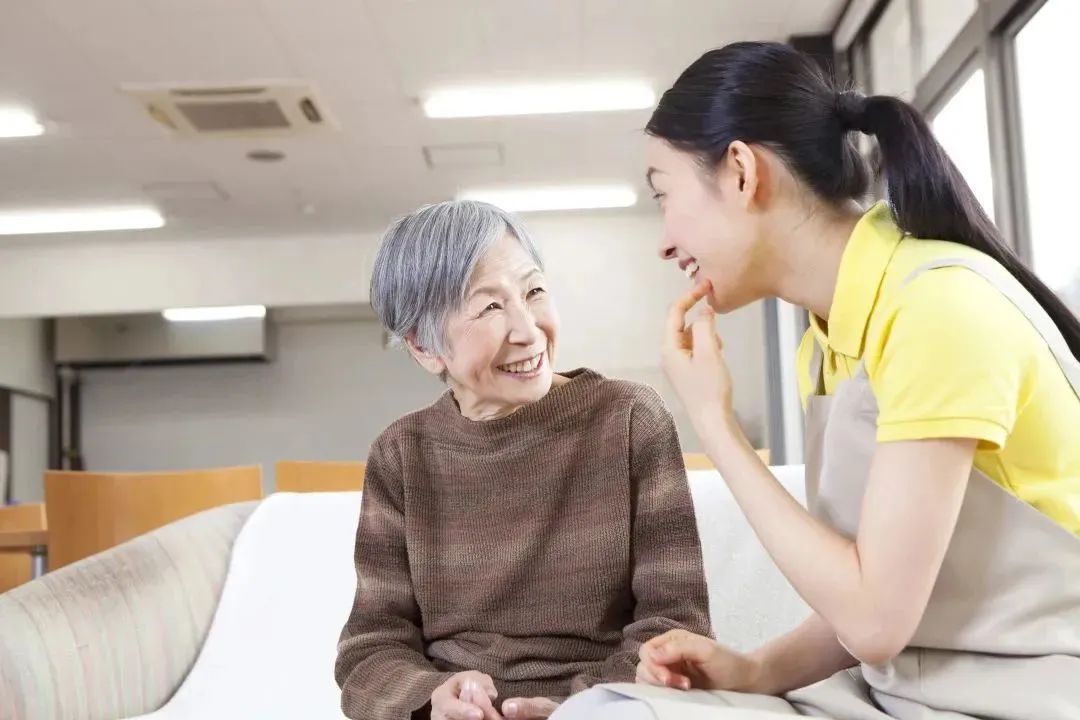 Senior resident converses joyfully with staff member