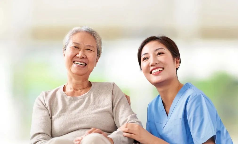 Caregiver and smiling senior resident together