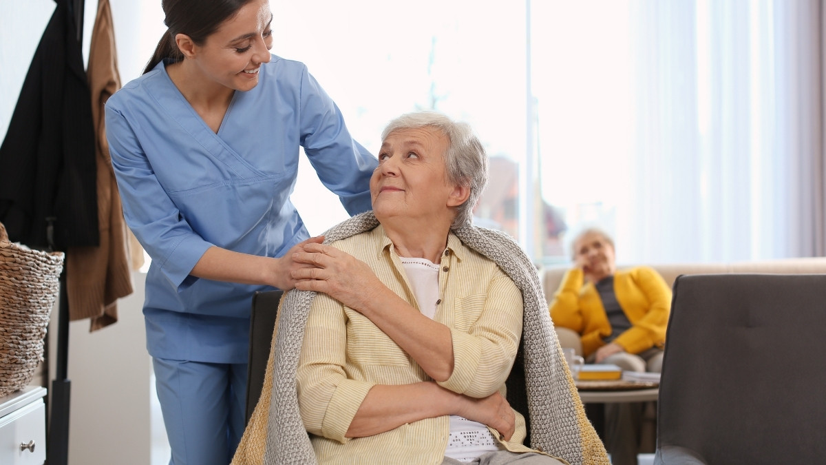 Caregiver assisting an elderly resident indoors