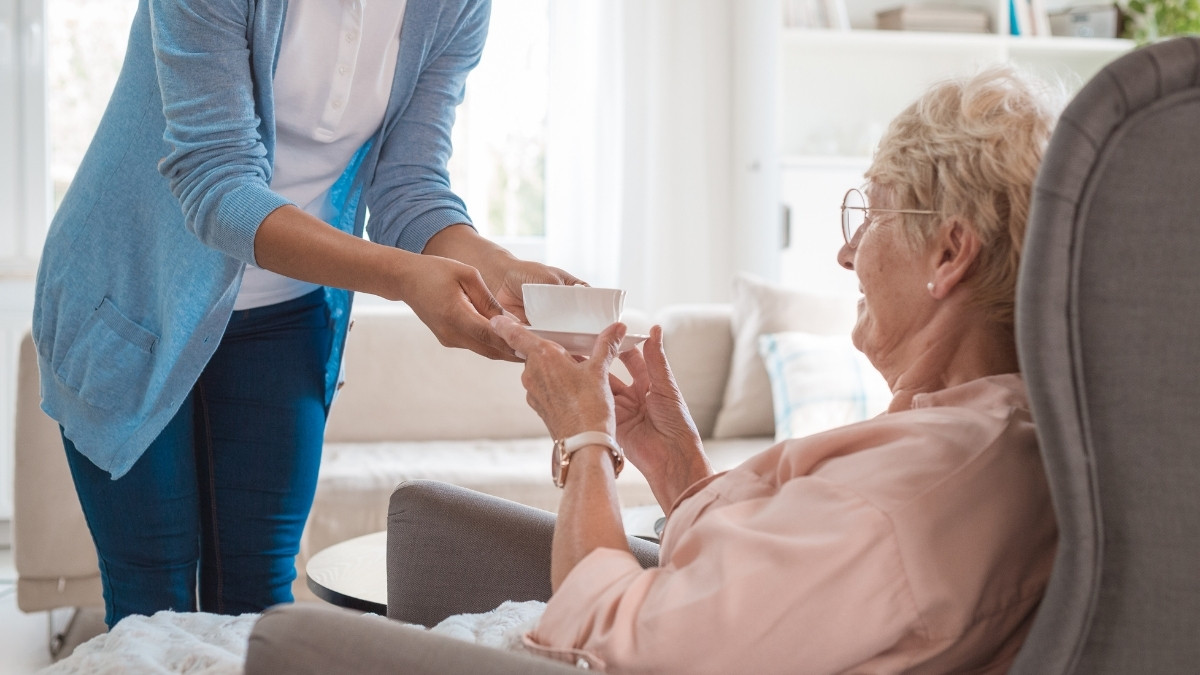 Caregiver assisting a resident with a drink