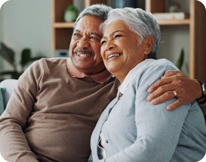 Senior couple smiling together on a couch