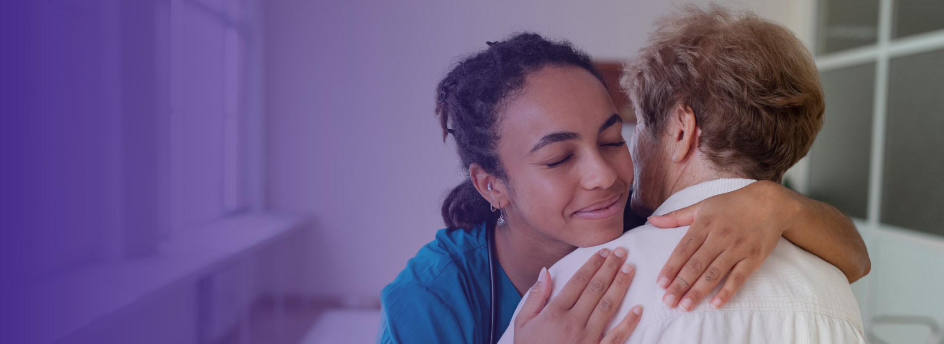 Caregiver embracing a resident in a warm setting.