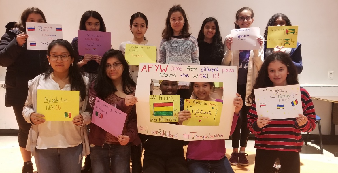 Group of young people holding colorful signs.