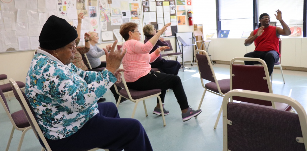 Seniors participating in an exercise activity indoors.