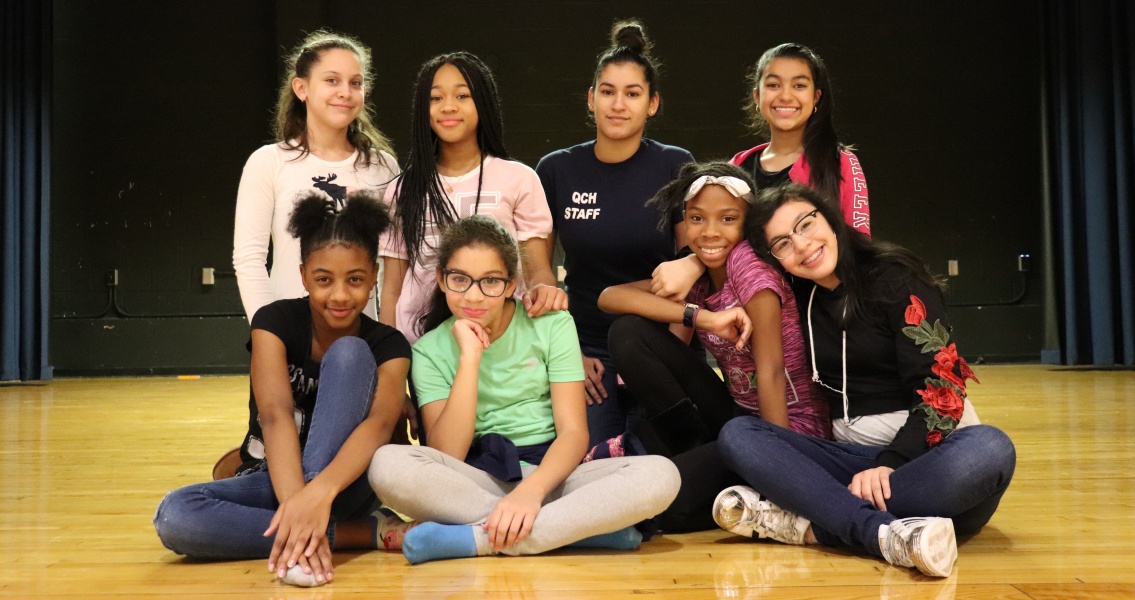 Group of children and staff posing together indoors.