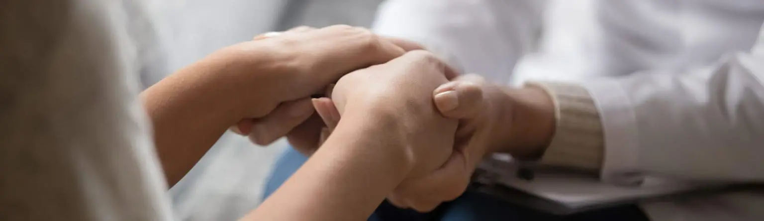 Two hands clasping in a supportive gesture
