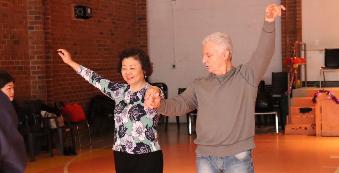 Seniors dancing together in a community space.