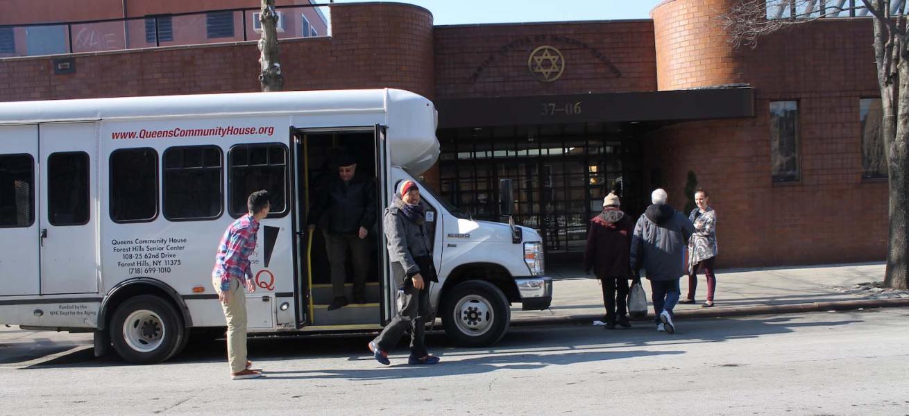 Residents and staff near facility bus outside
