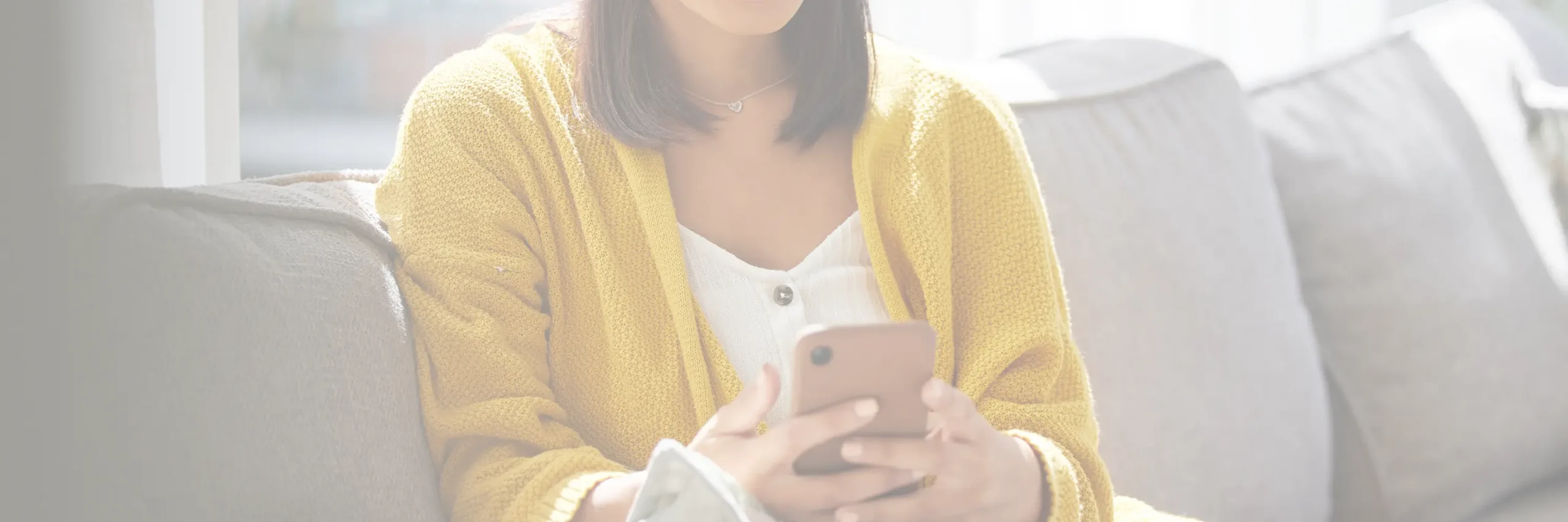 Woman in cozy sweater using a smartphone.