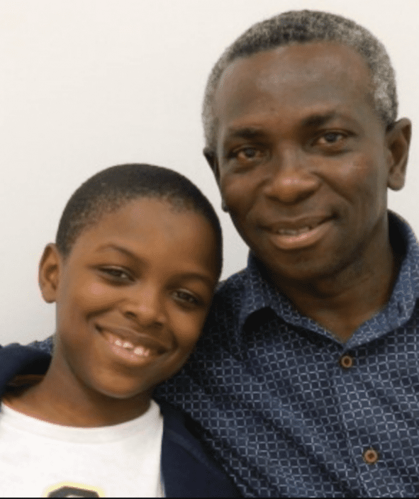 Smiling man and boy posing together.