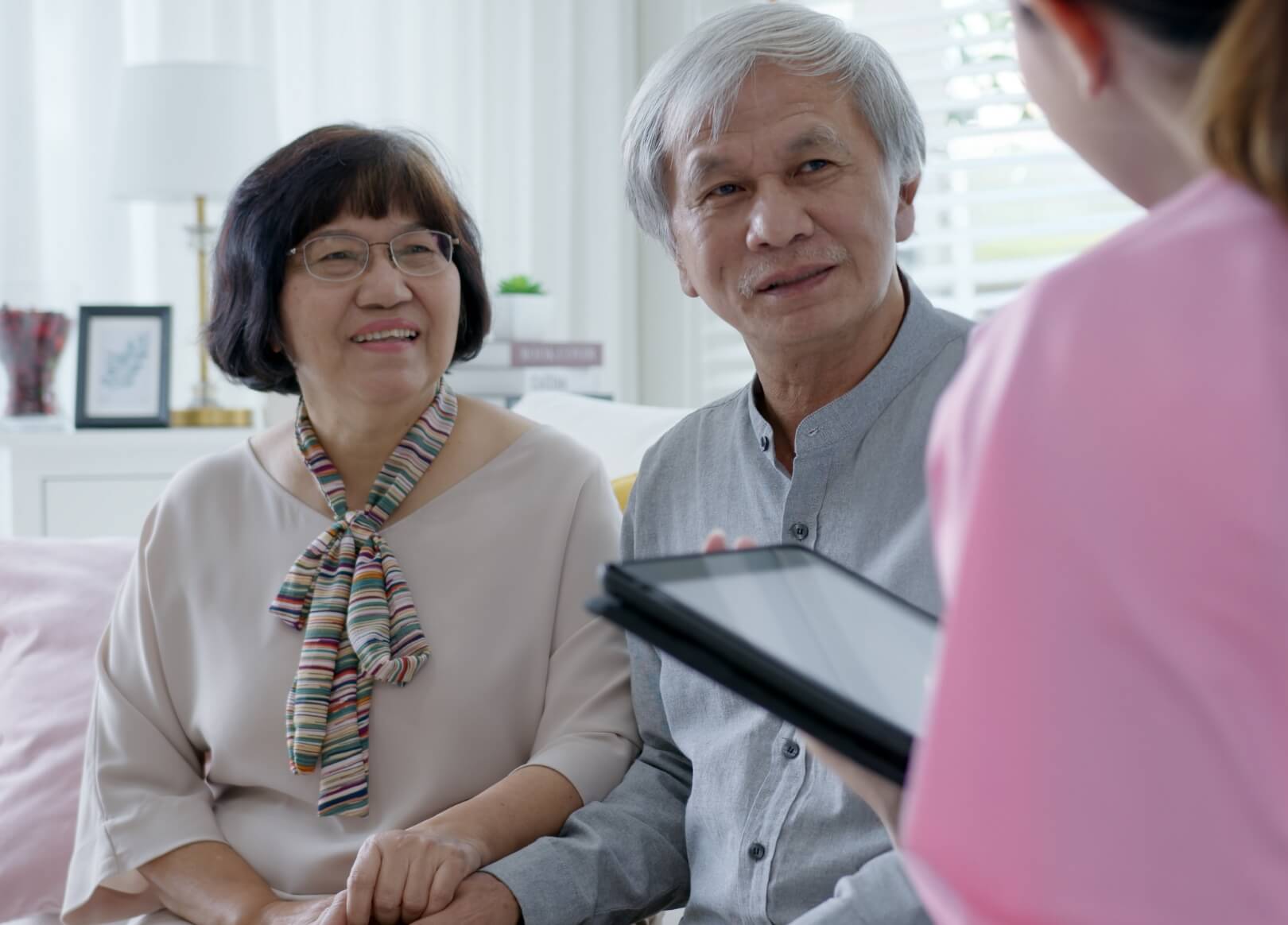 Senior couple engaged in conversation with staff
