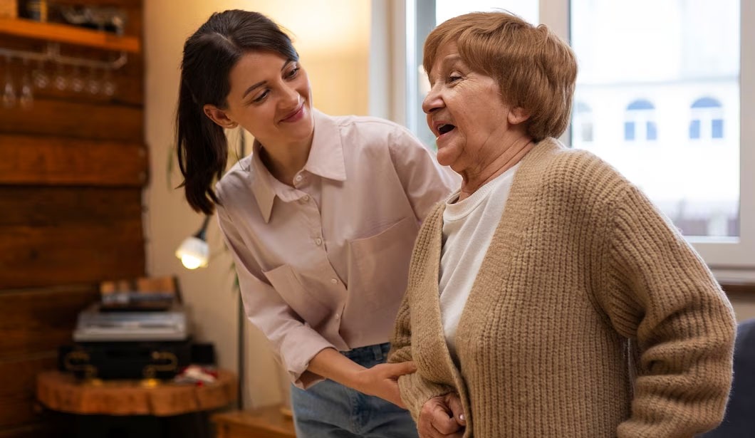 Staff assisting a resident in a cozy common area.