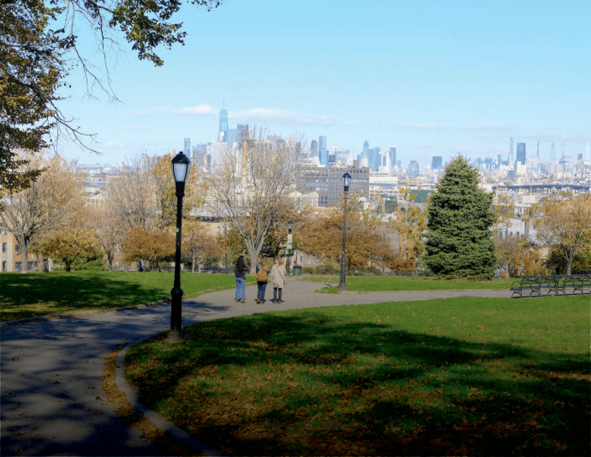 Two people walking in a park with city skyline
