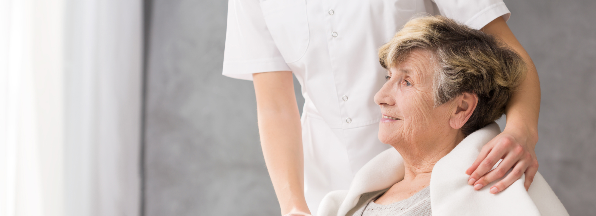 Nurse interacting with an elderly resident indoors.