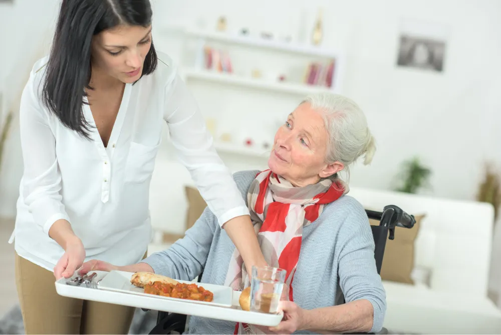 Caregiver serving food to a resident